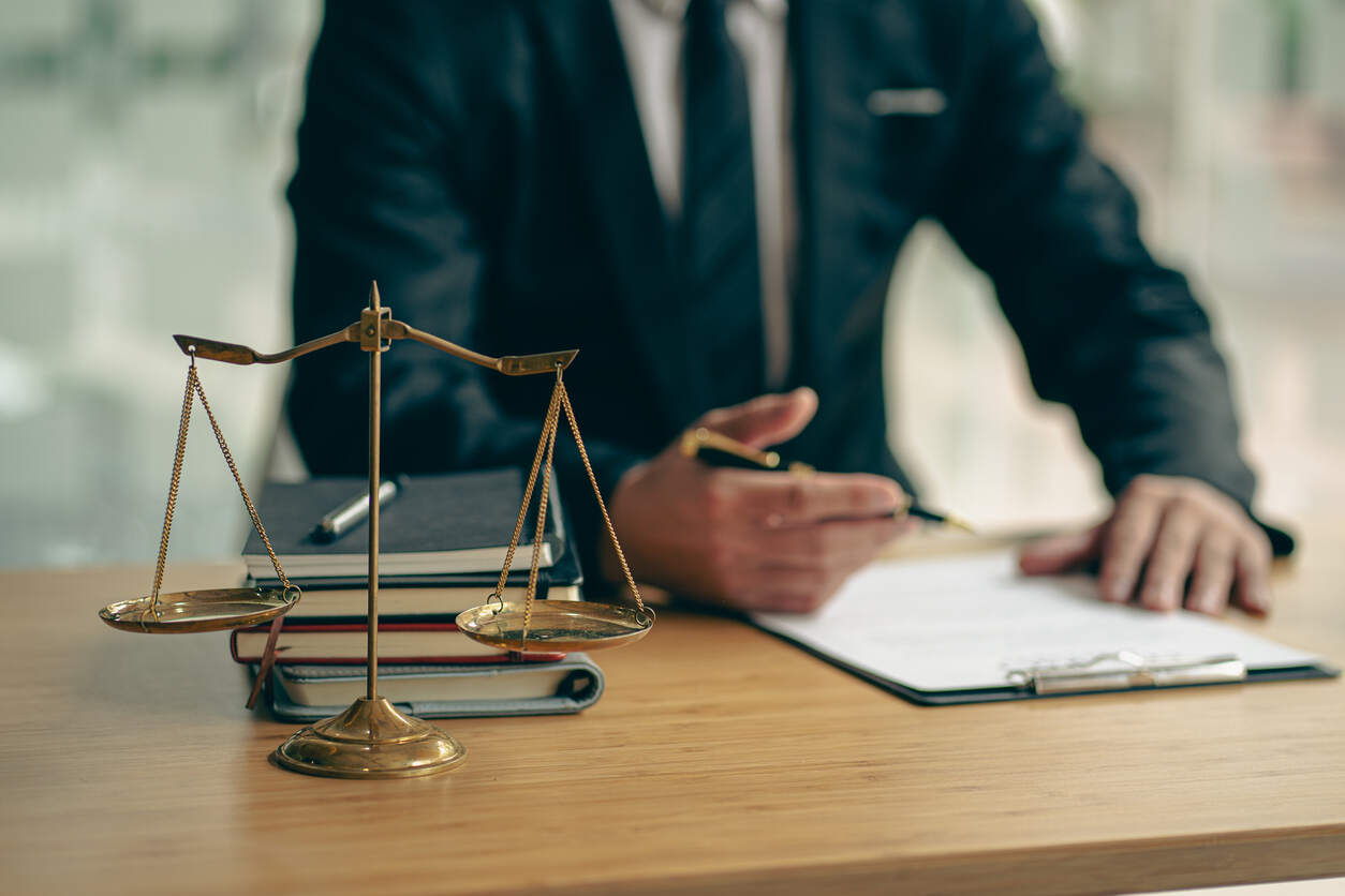 Lawyer pointing to documents on a desk with scales of justice, symbolizing personal injury lawyer.