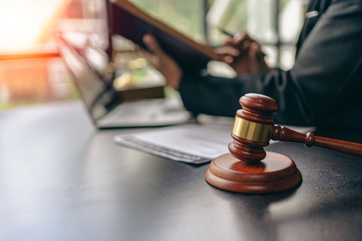Lawyer pointing to documents on a desk with lawyer gavel on the table symbolizing personal injury lawyer.