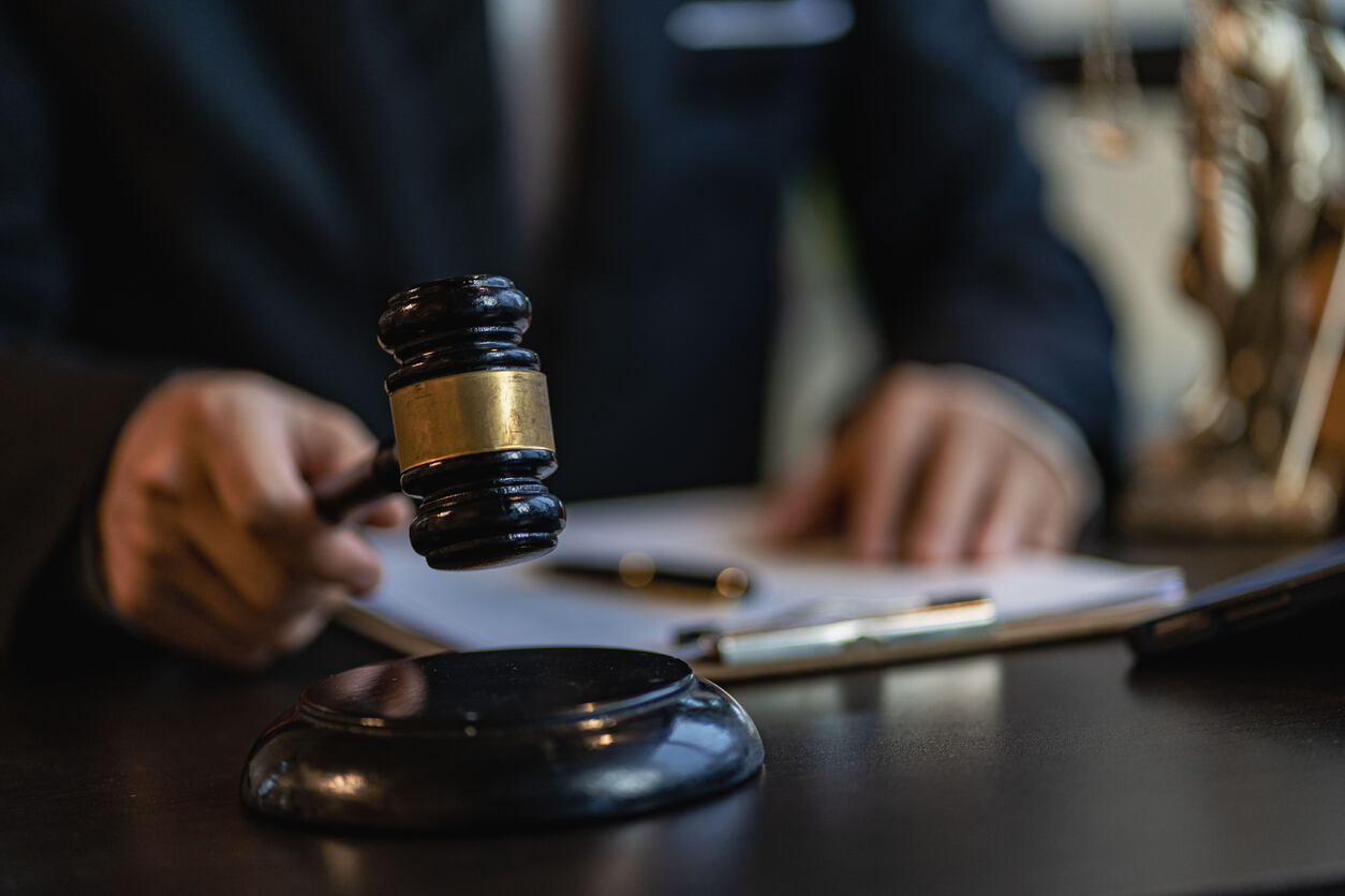 Lawyer working and holding gavel and checking document symbolizing personal injury law.