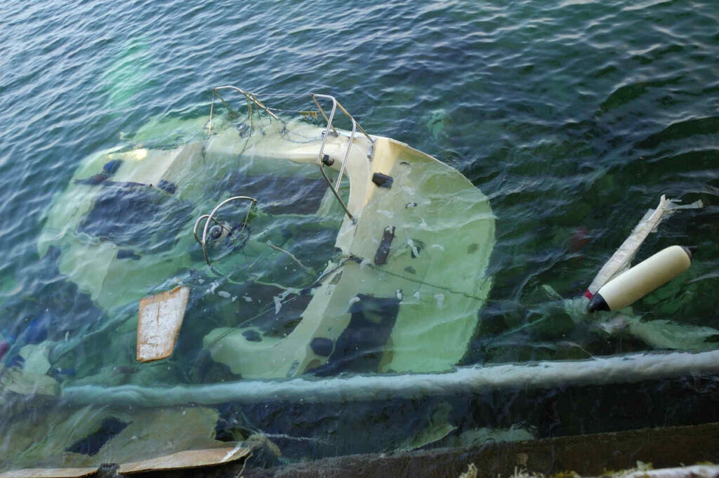 Destroyed sailboat lying aground after a severe windstorm, highlighting cases for Boating Accident Attorneys in Boise